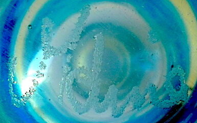 Blown blue glass bottle with inclusions