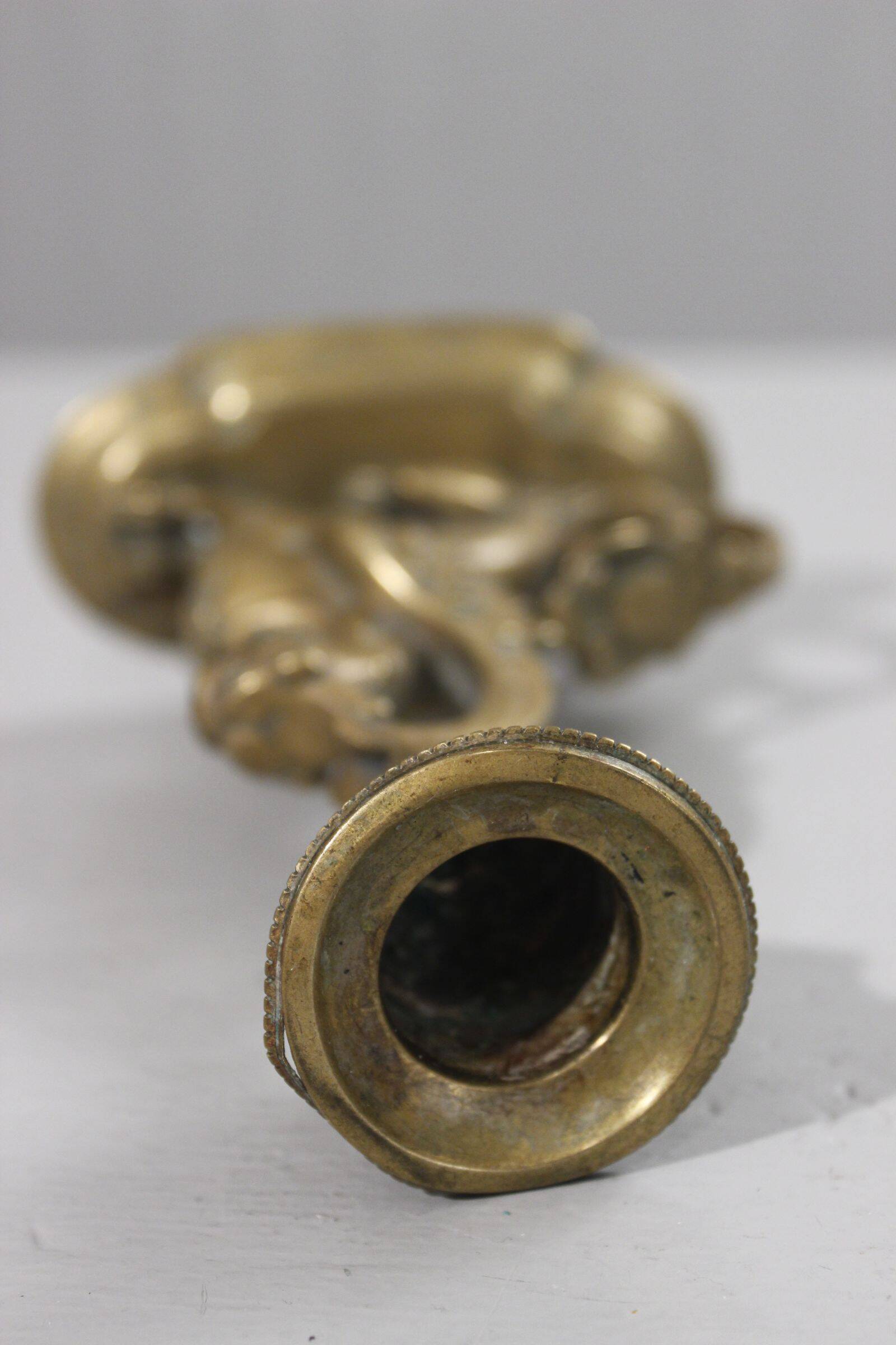 Handheld candlestick in bronze featuring a griffin, 19th-century Empire style.