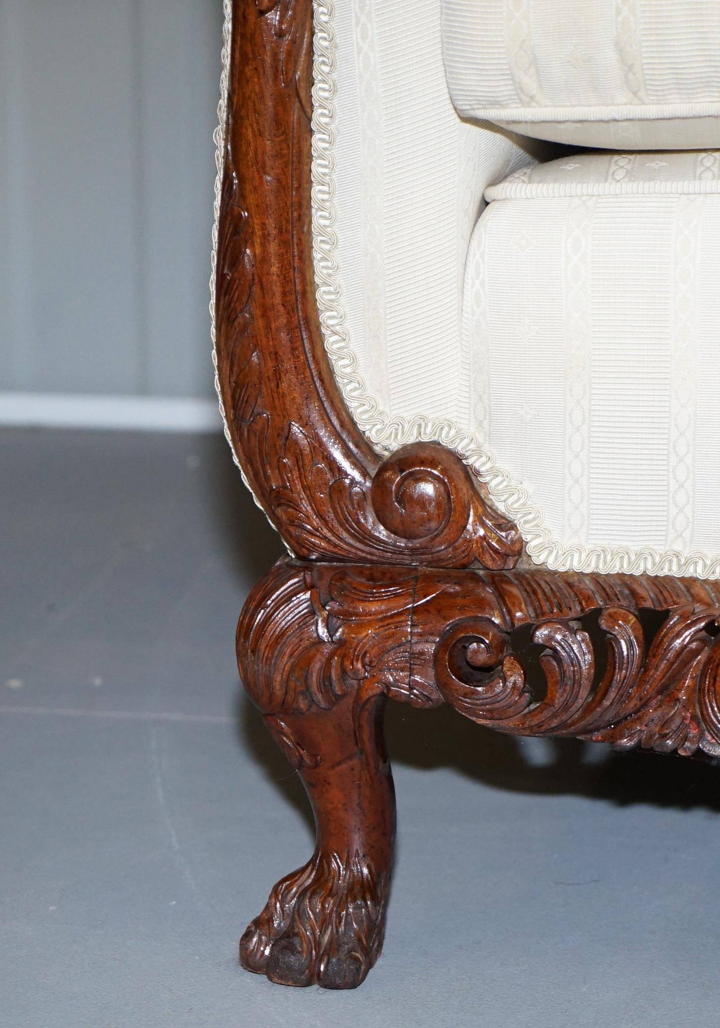Three-seater canapé carved from solid walnut with claw feet.