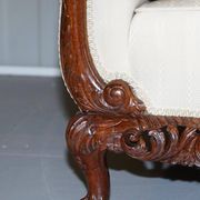 Three-seater canapé carved from solid walnut with claw feet.
