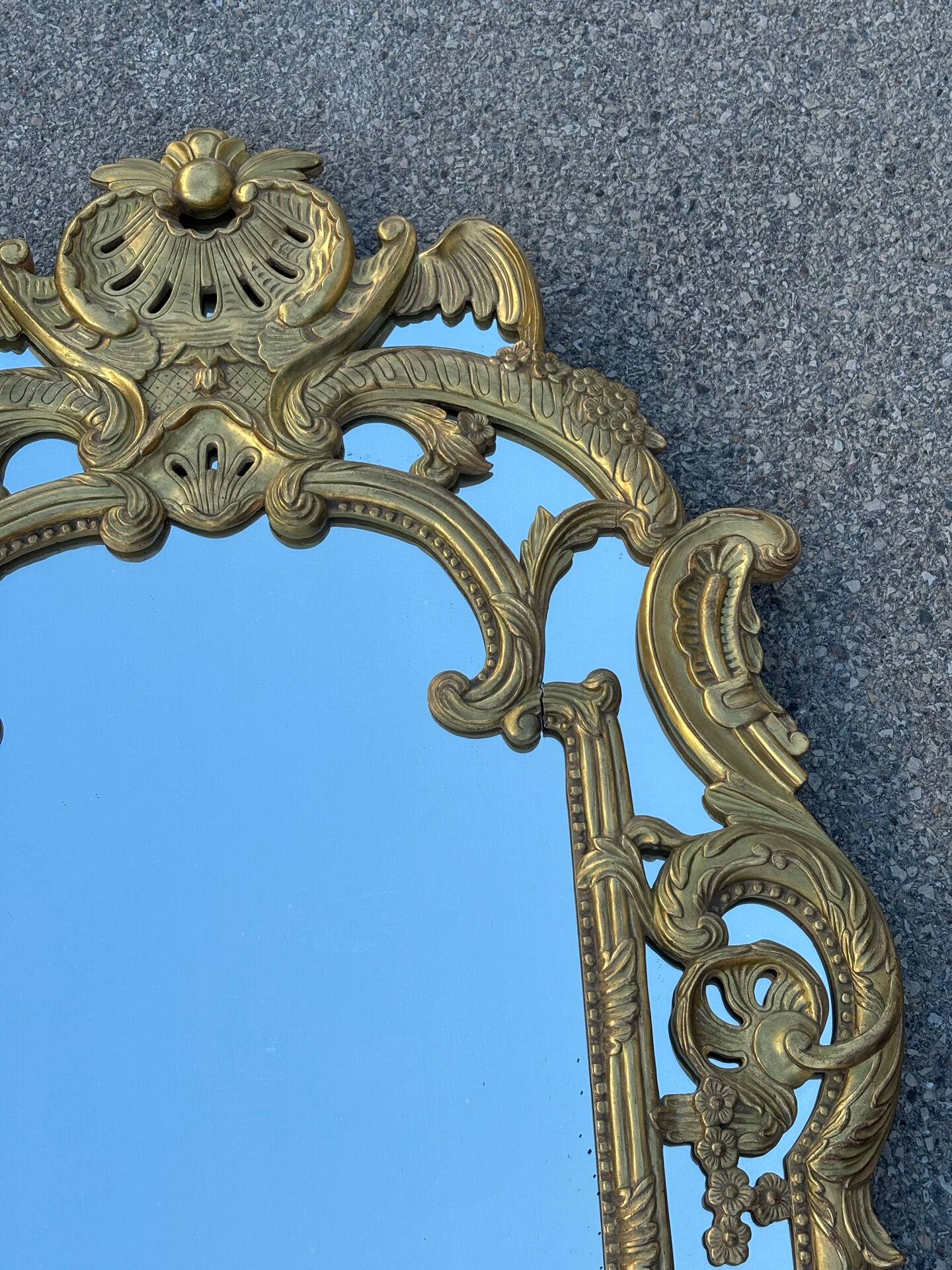 Large mirror with carved and gilded wooden frame, in Regency style.
