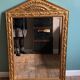 Mirror in gilded wood with a triangle pediment decorated with half sunflowers