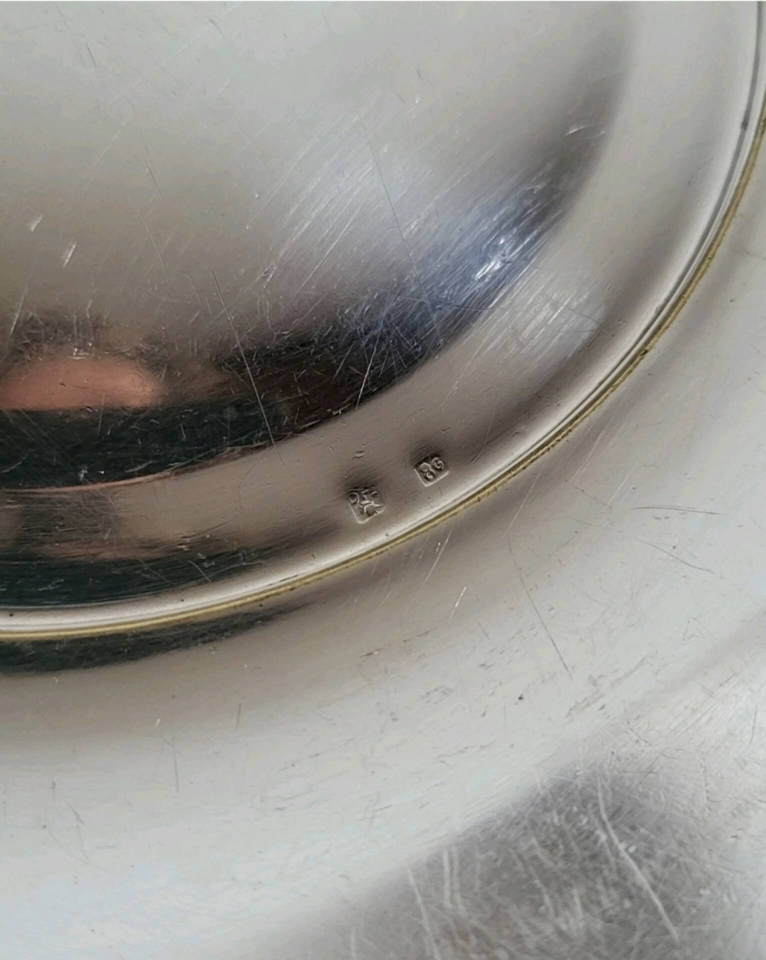 Shallow round metal plate with pearl row decoration.