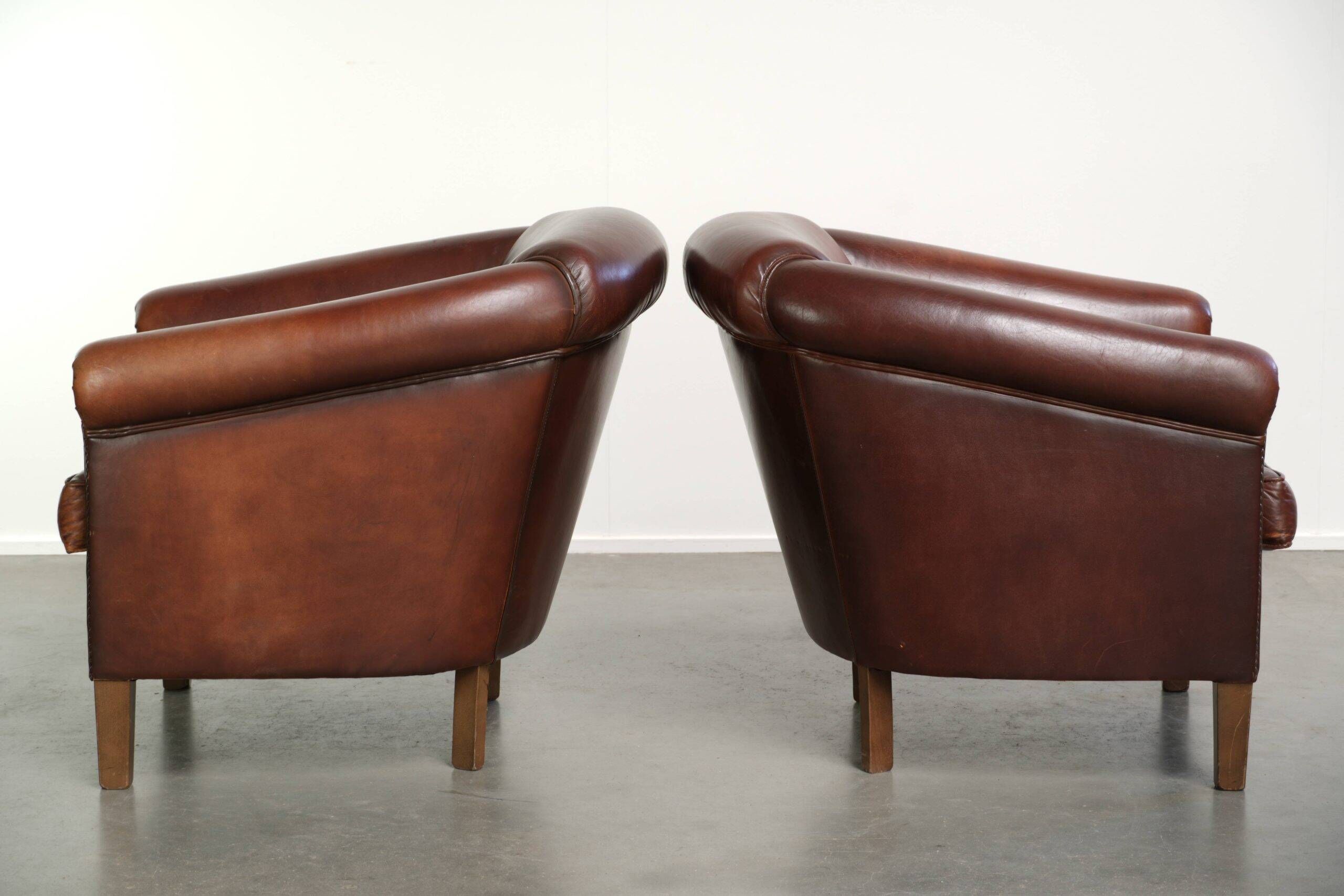 Set of 2 sheepskin club armchairs in a dark cognac colour