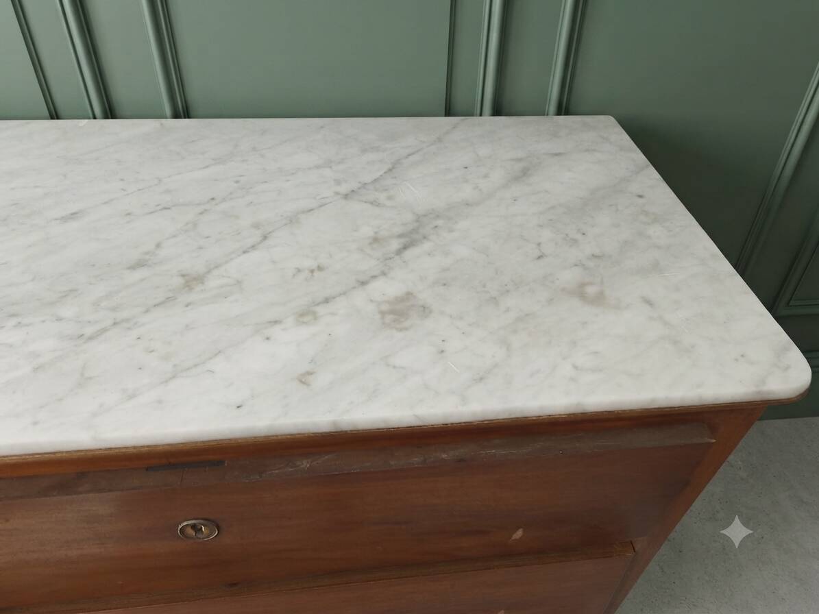 Antique solid wood chest of drawers with a white marble top.