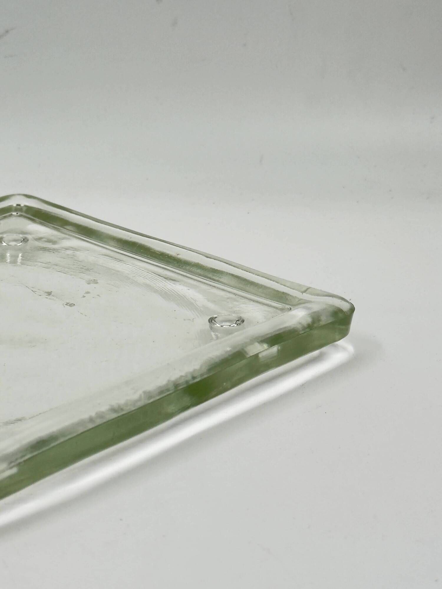 Vintage square serving tray in pale green tinted transparent glass with raised feet.