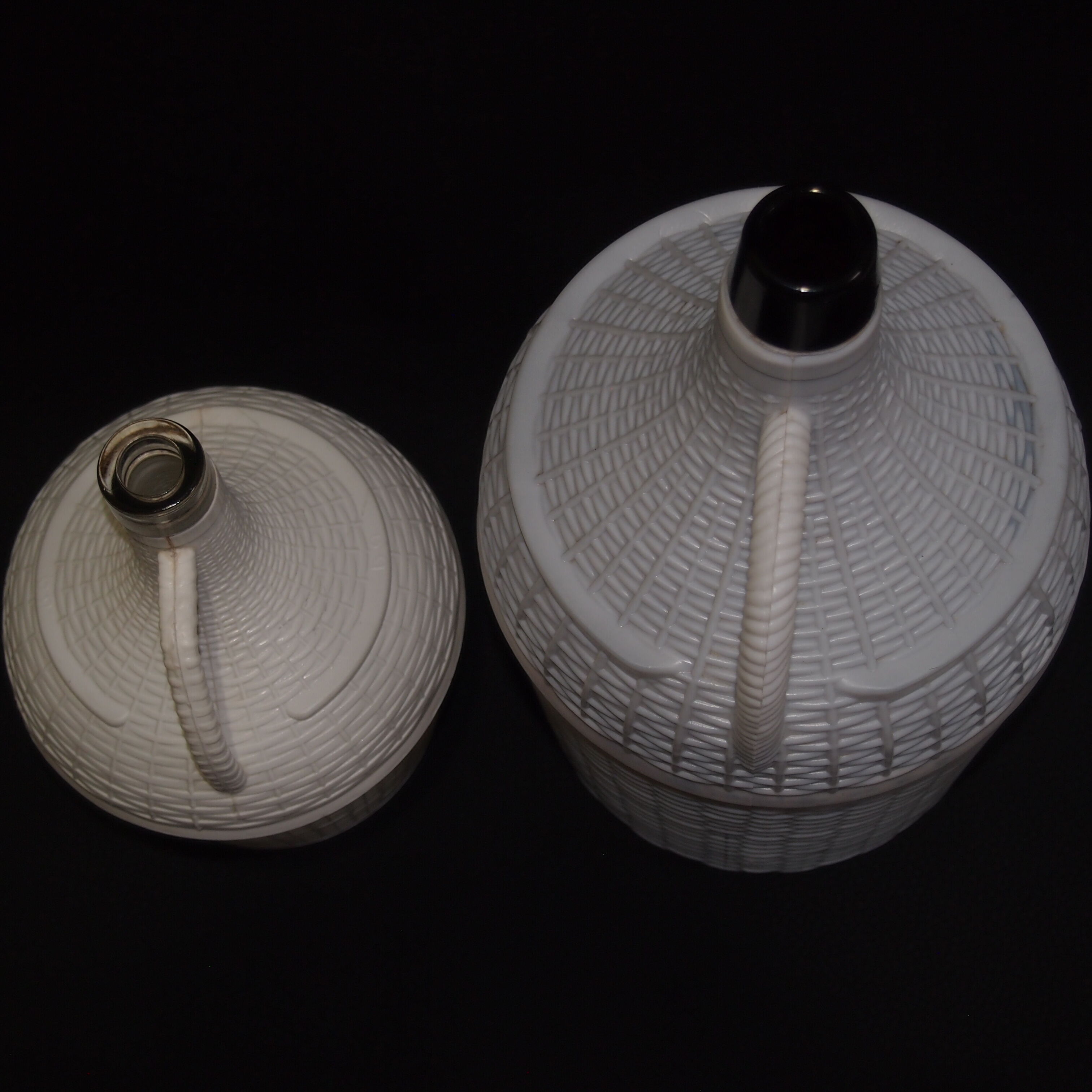 Pair of white covered demijohns