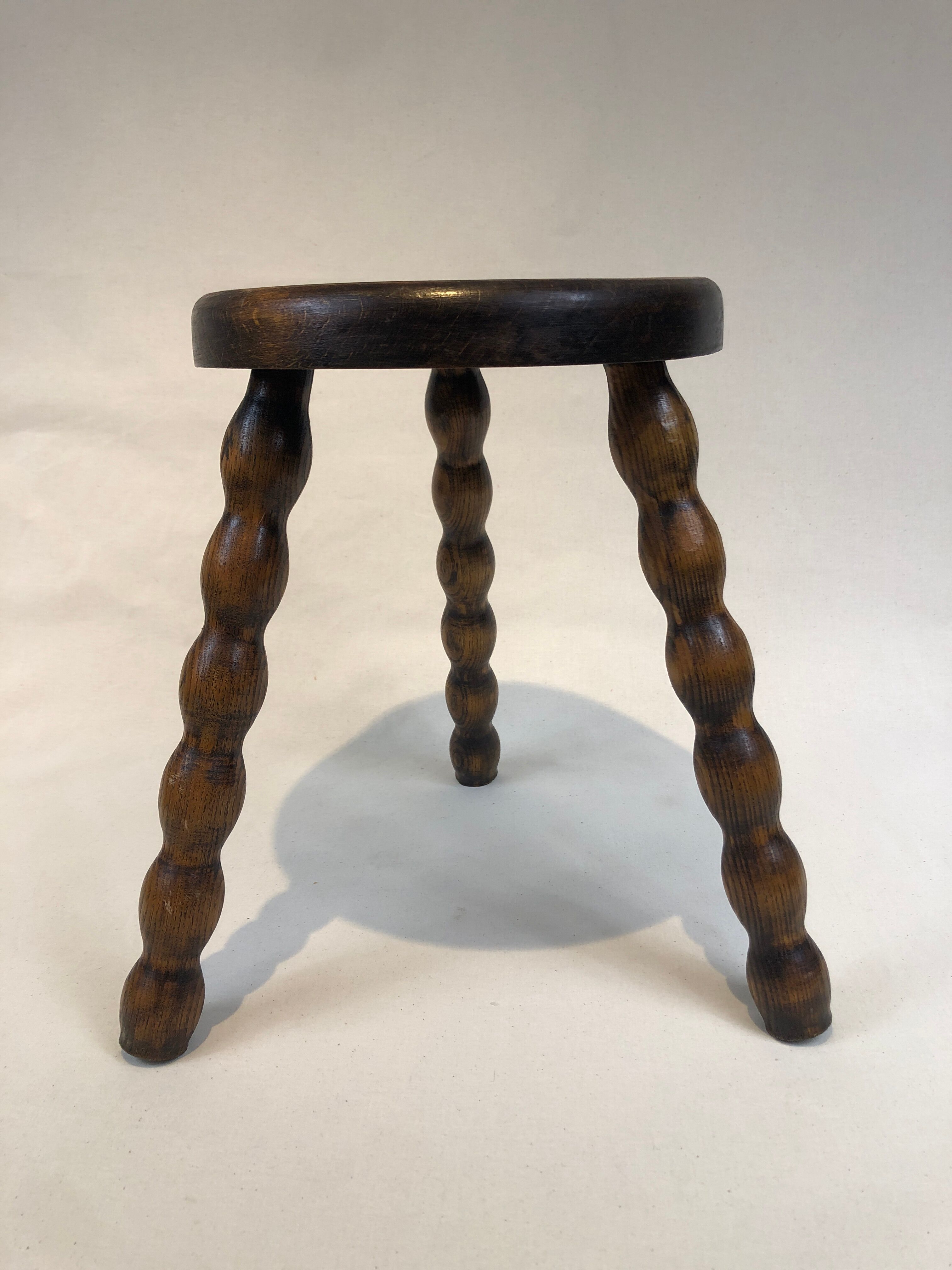 Dark turned wood tripod stool