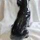 Statue of a roaring panther/leopard sitting in black glazed ceramic.