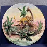 Plat en céramique figurant un lion attaquant une girafe
