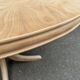 Renovated oval Scandinavian extendable dining table in wood with a central leg.