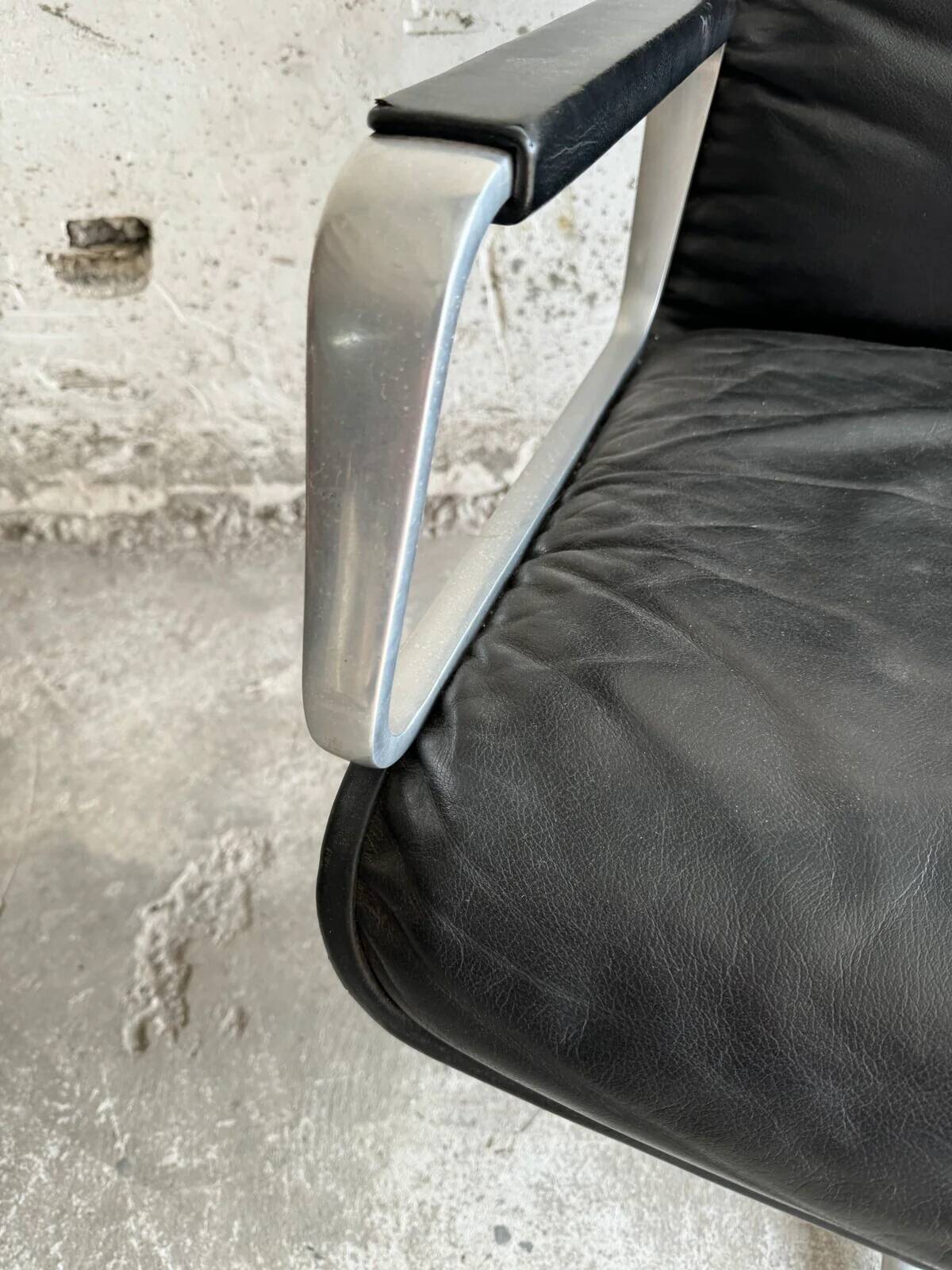 Wilkhahn Delta lounge chair in black leather with polished aluminum base and footrest (1970s)