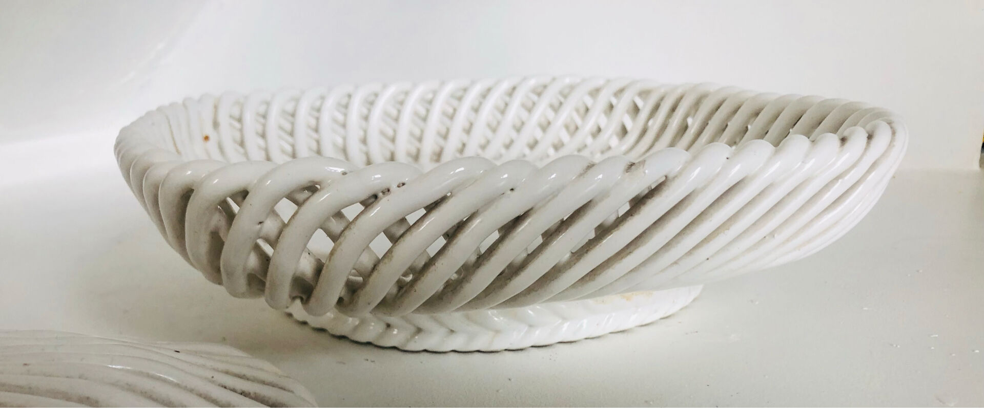 Covered basket in white woven ceramic and fruit slip.