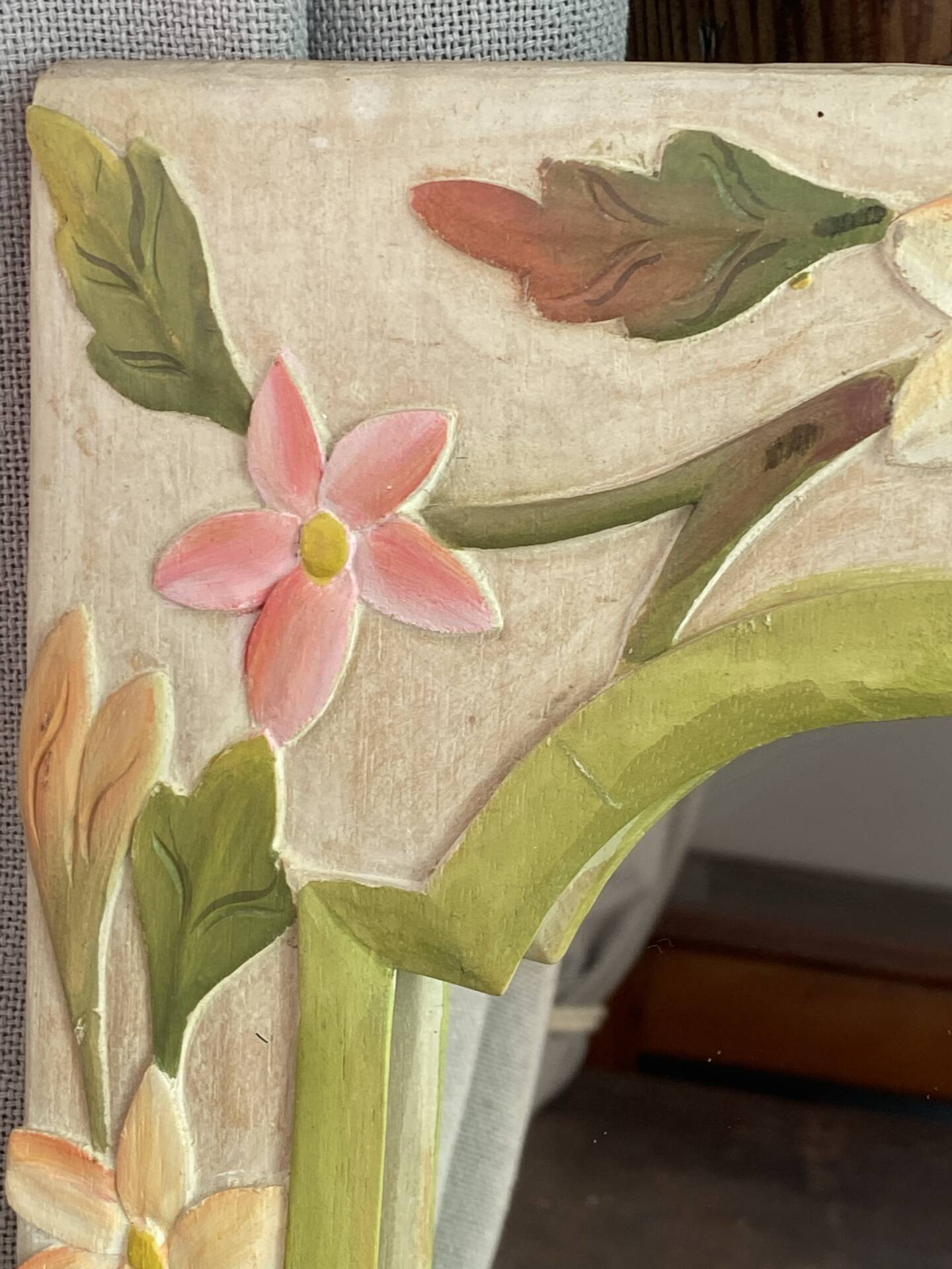 Carved wooden mirror, colourful floral decoration.
