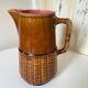 Antique vintage ceramic pitcher or jug from Sarreguemines, France. Brown with a pink interior, imitation basket.