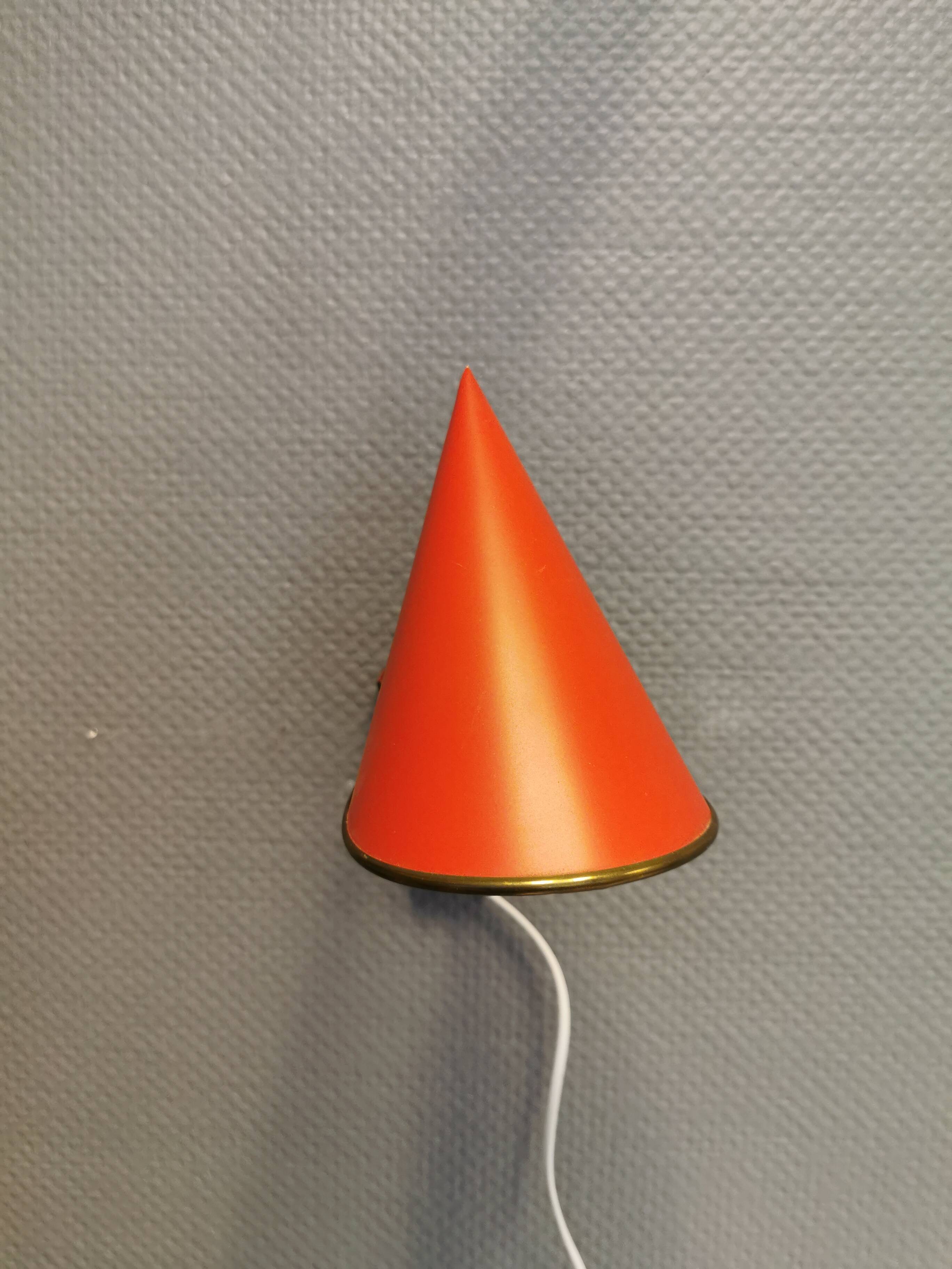 Danish red lacquered wall light with brass details. Estimated 1980s