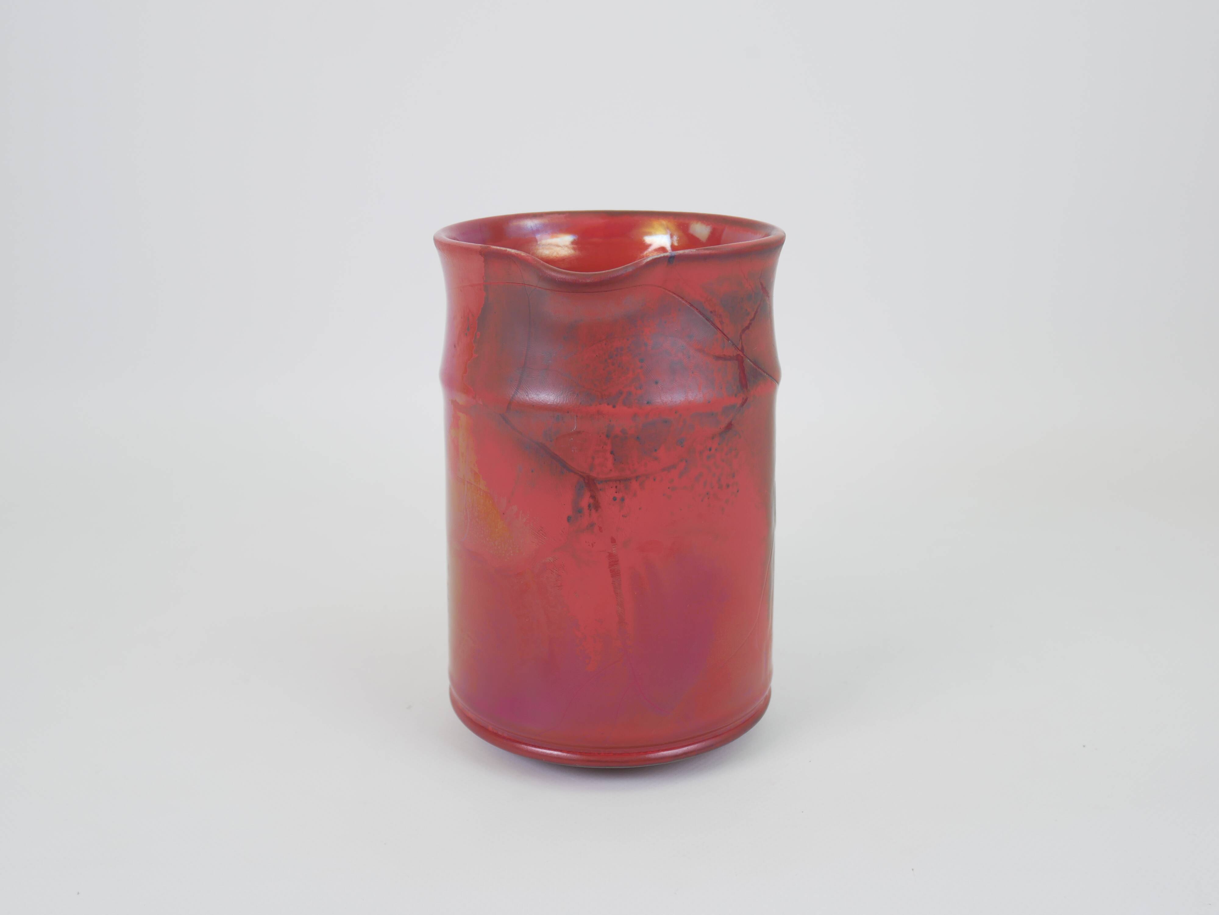 Red glazed ceramic jug with relief