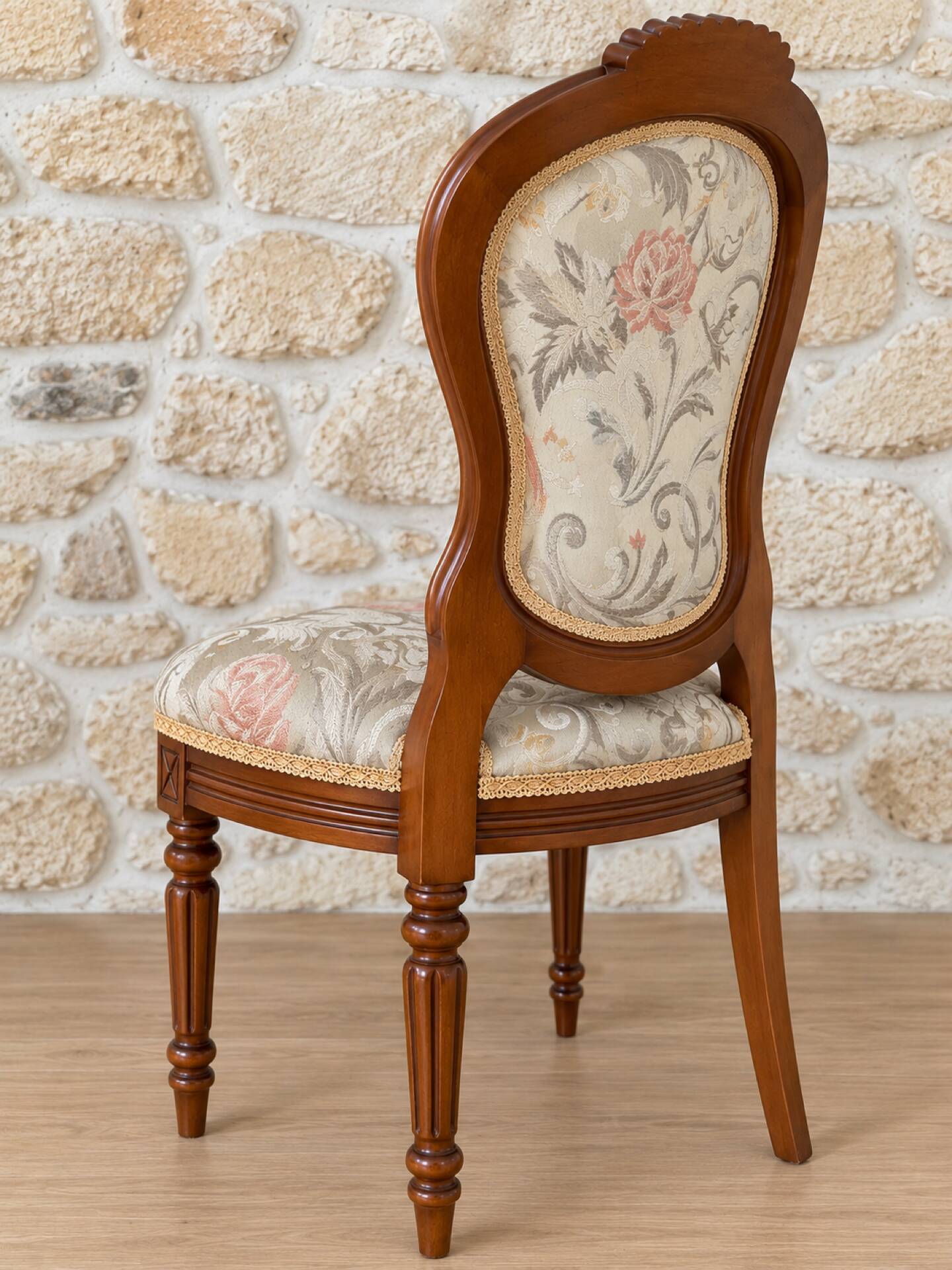 Antique Louis XVI style chair in wood and floral fabric.