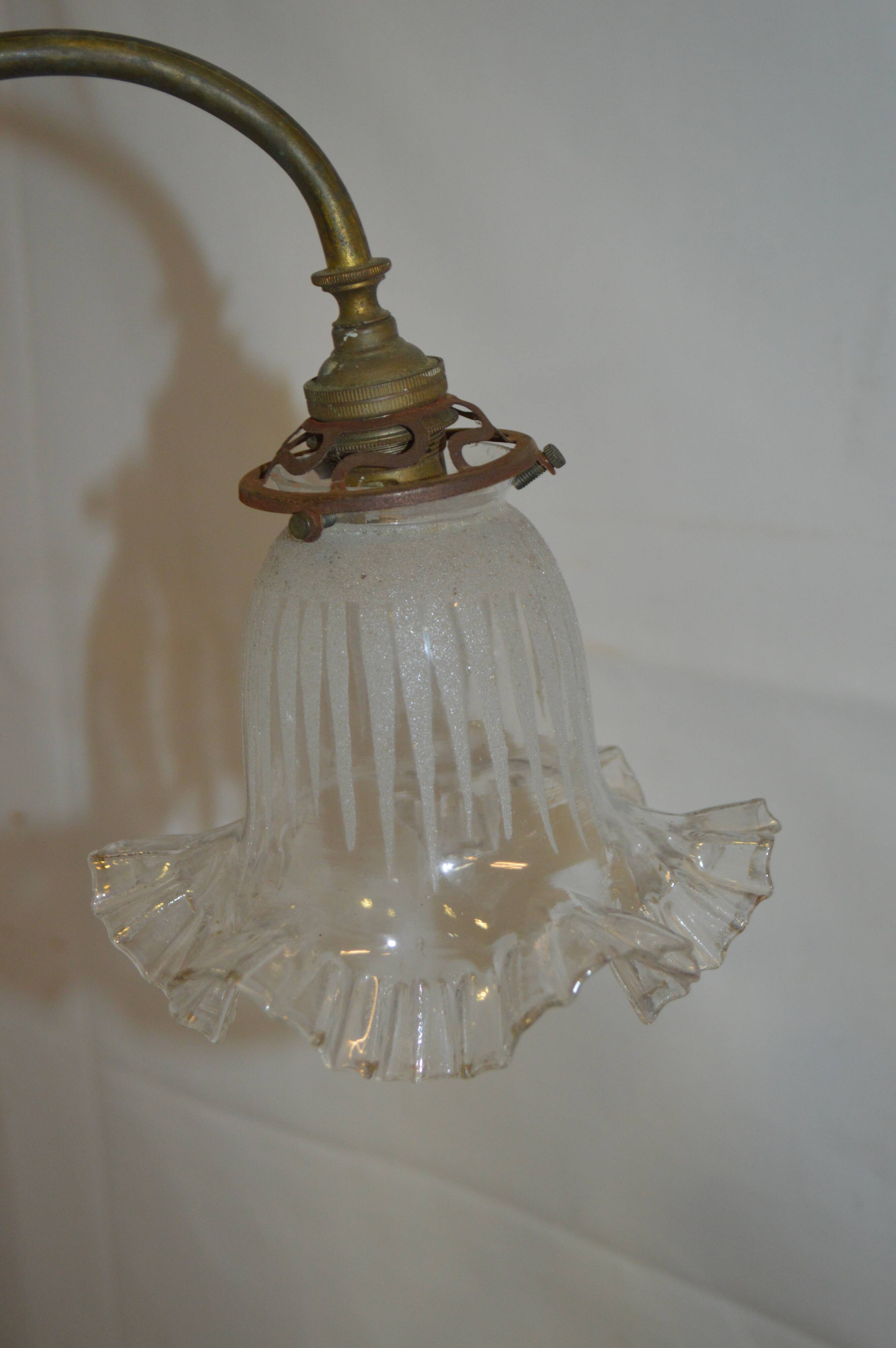 Brass wall sconce with a glass tulip