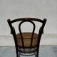Thonet armchair stamped with curved wooden armrests and caning from the 19th century.