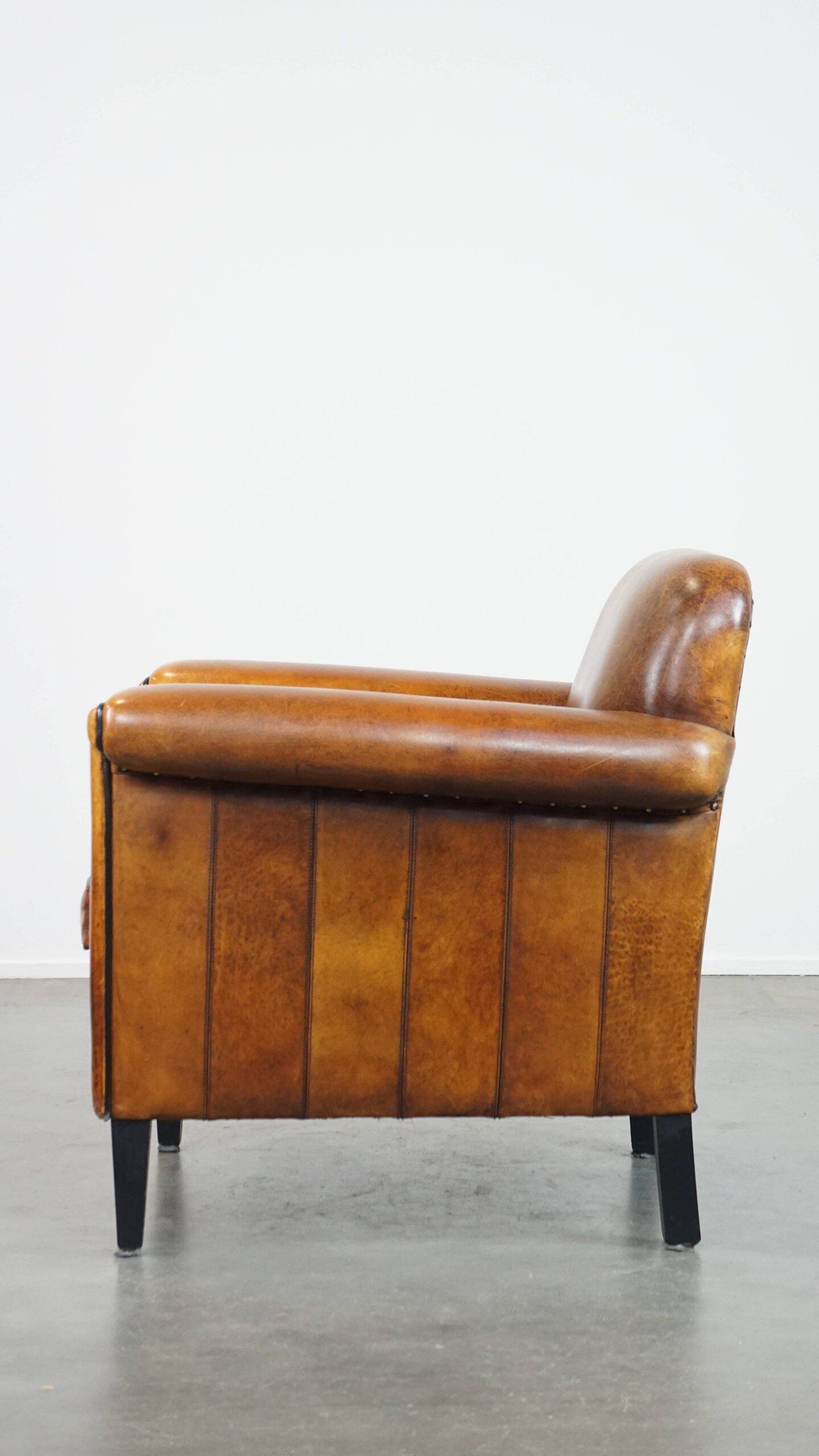 Sheepskin Art Deco design armchair with sleek finish and black piping