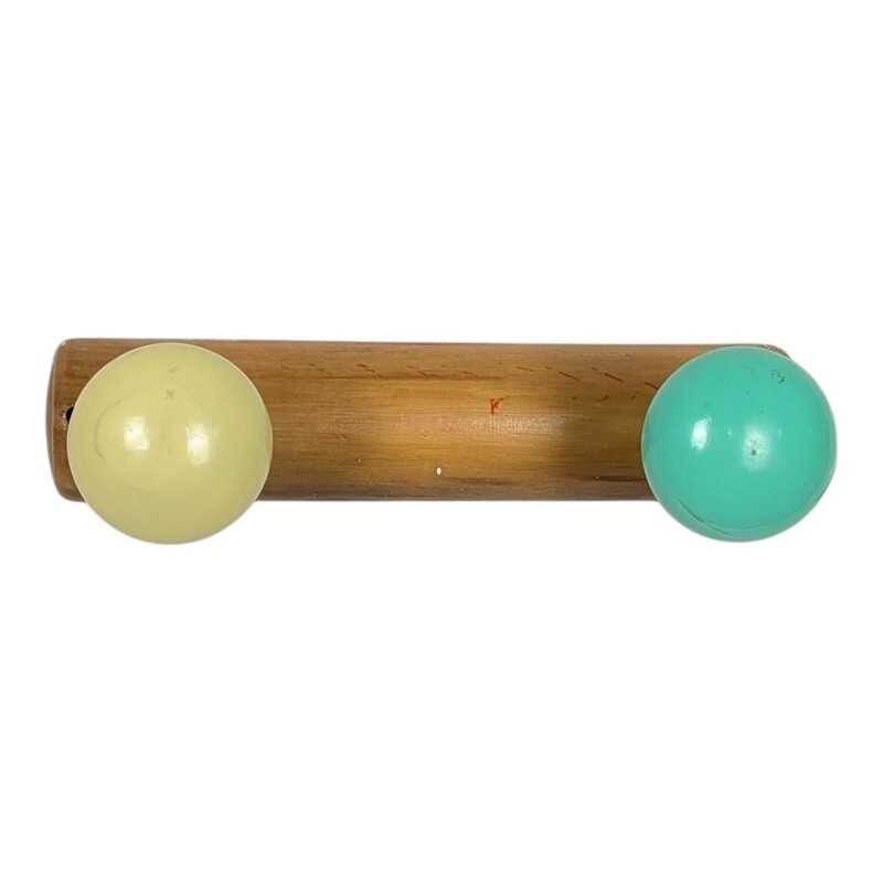 Vintage wall coat rack with 2 yellow and green balls.