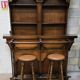 Solid wood bar cabinet with shelves and two stools.
