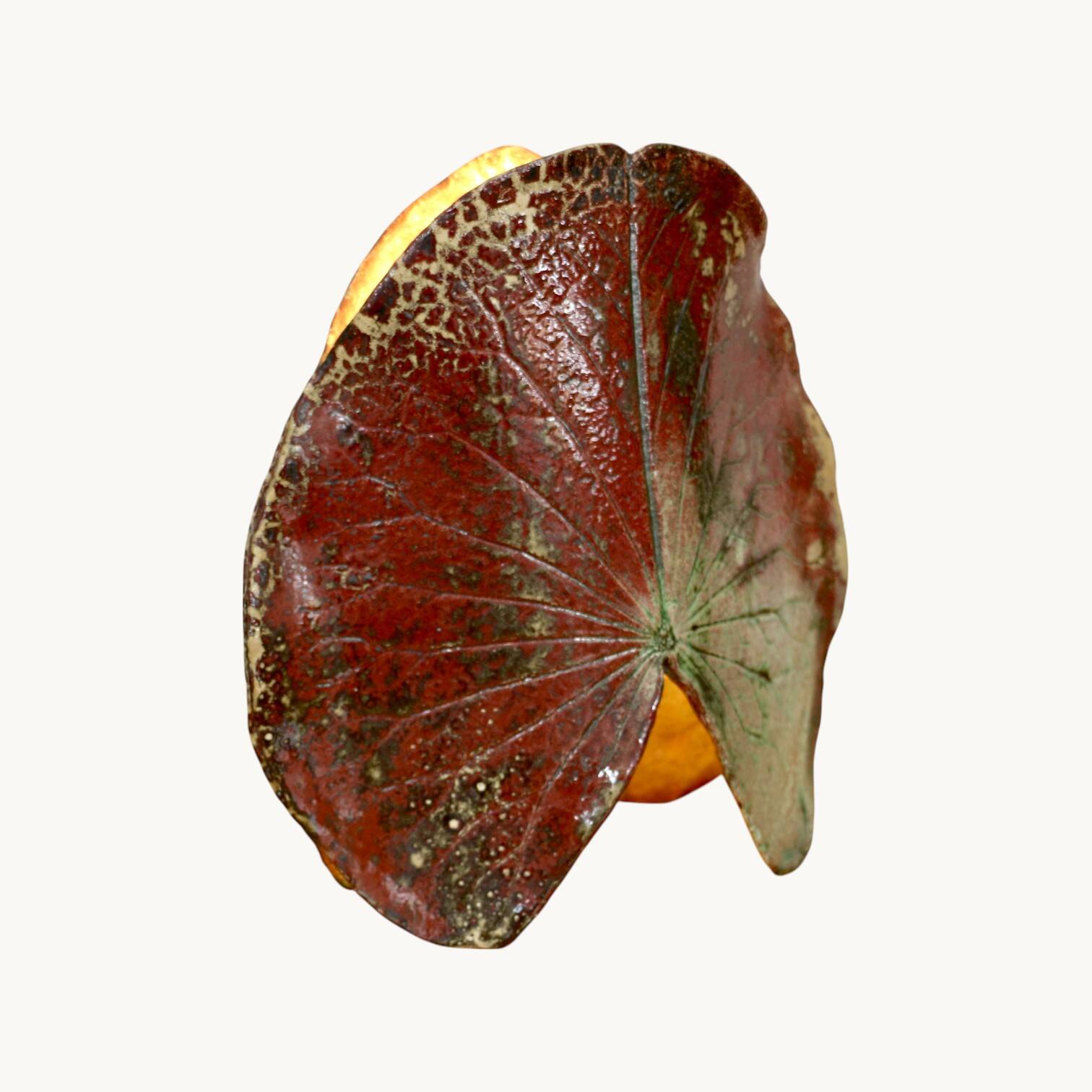 A ceramic lamp in the shape of a leaf.