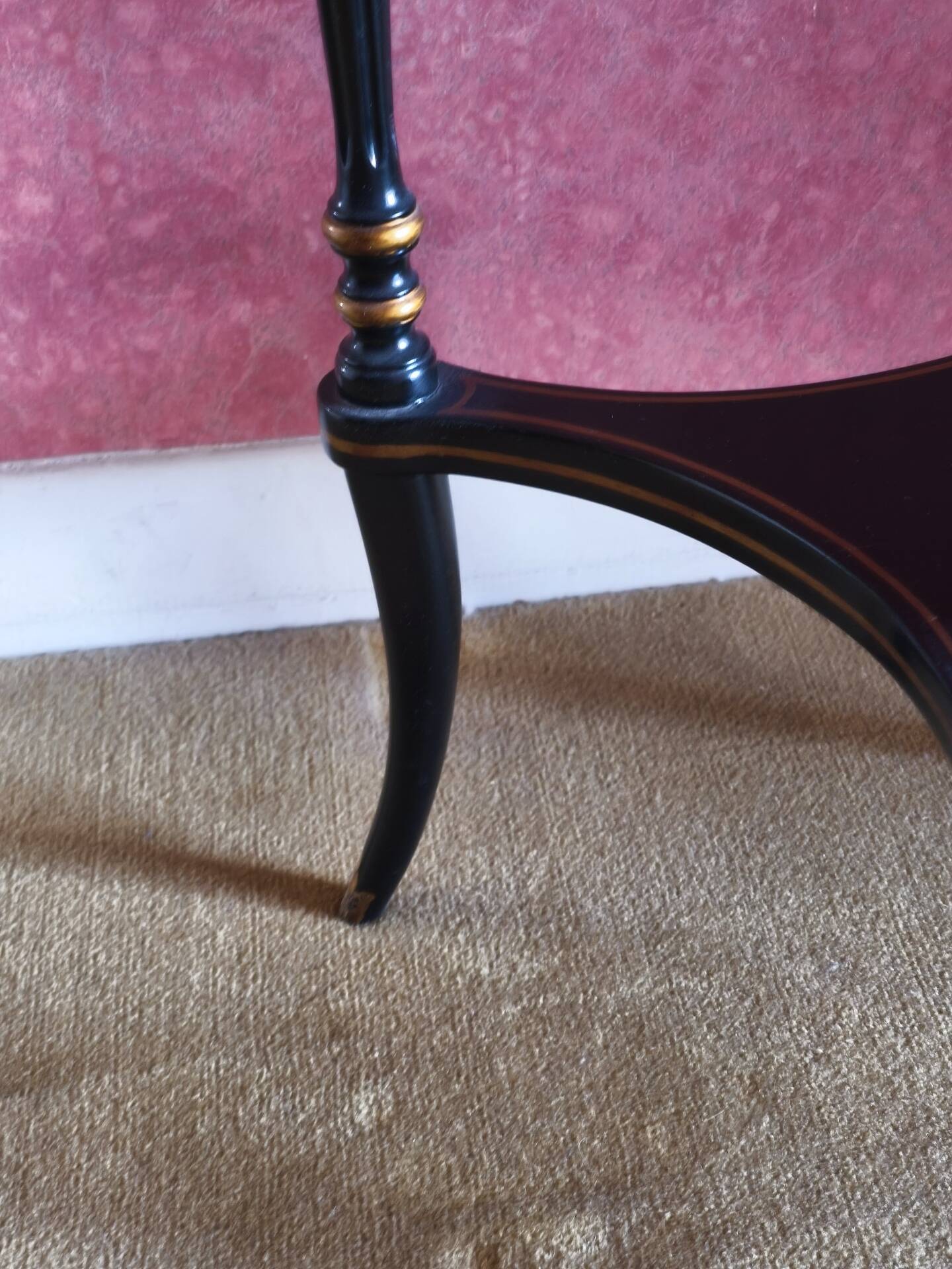Tripod stool in blackened wood with painted floral decoration.