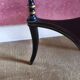 Tripod stool in blackened wood with painted floral decoration.