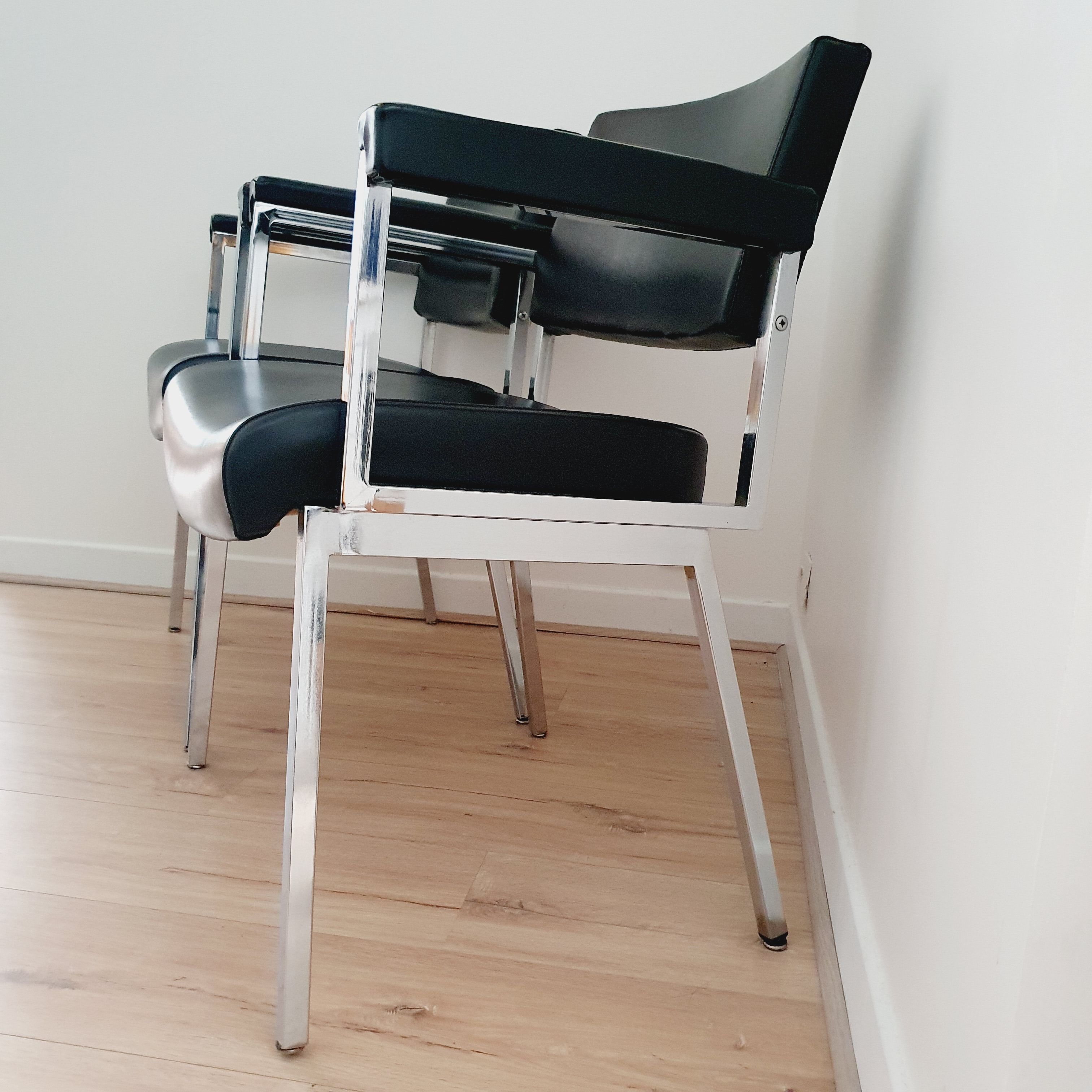 Pair of black skaï and chrome armchairs