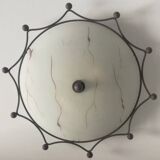 Round ceiling light with a wrought iron frame.