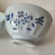 Two vintage farm bowls on a pale blue pedestal with floral decoration.