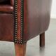 Vintage sheepskin club armchair with decorative nails and black piping