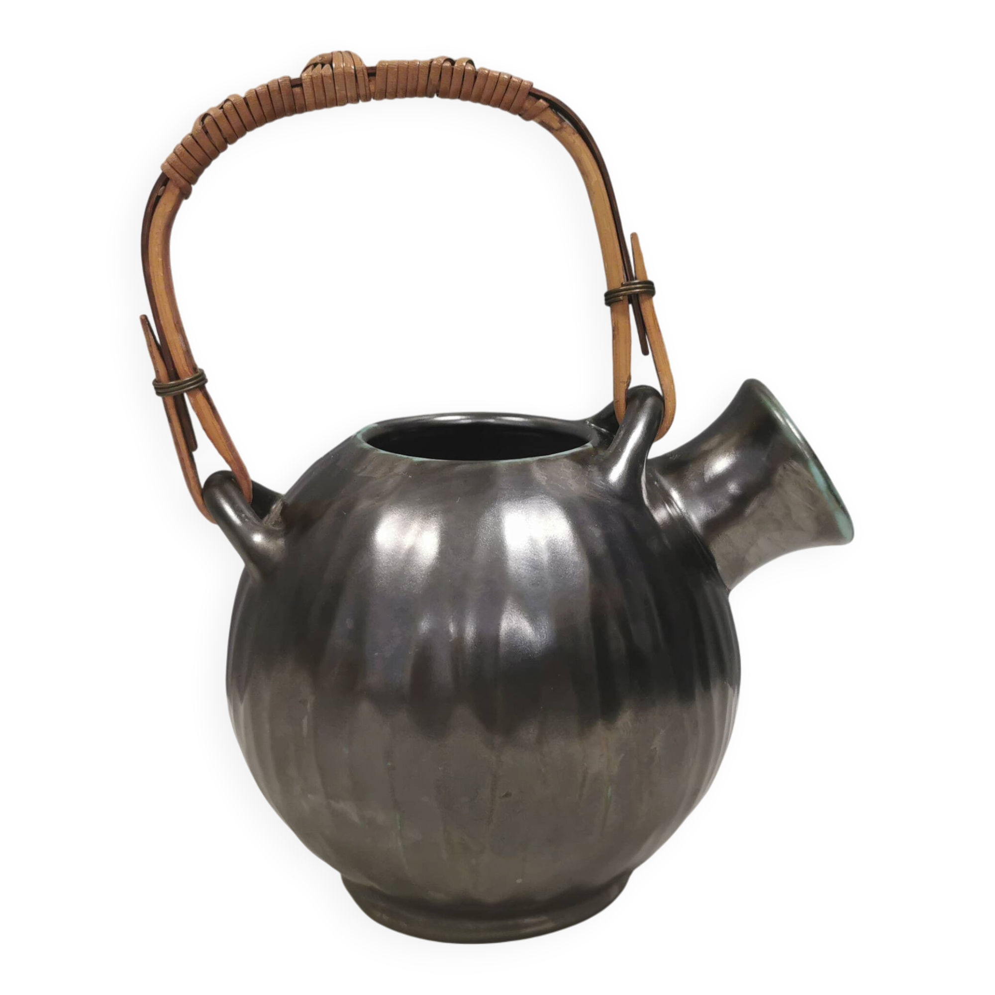 A ceramic jug with a metallic glaze and a handle made of woven raffia.