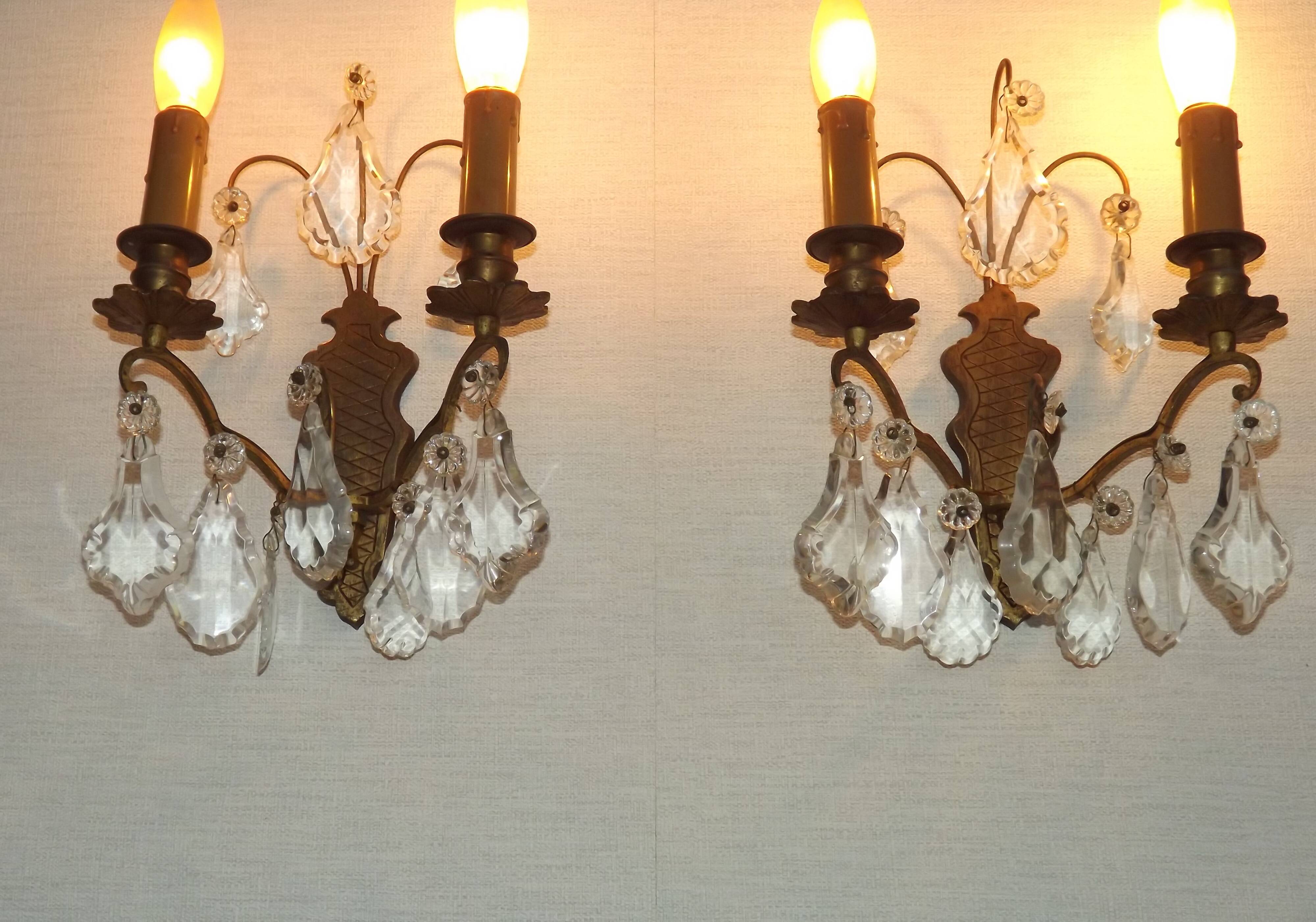 Pair of French antique brass double wall lights with assorted crystals.