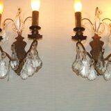 Pair of French antique brass double wall lights with assorted crystals.