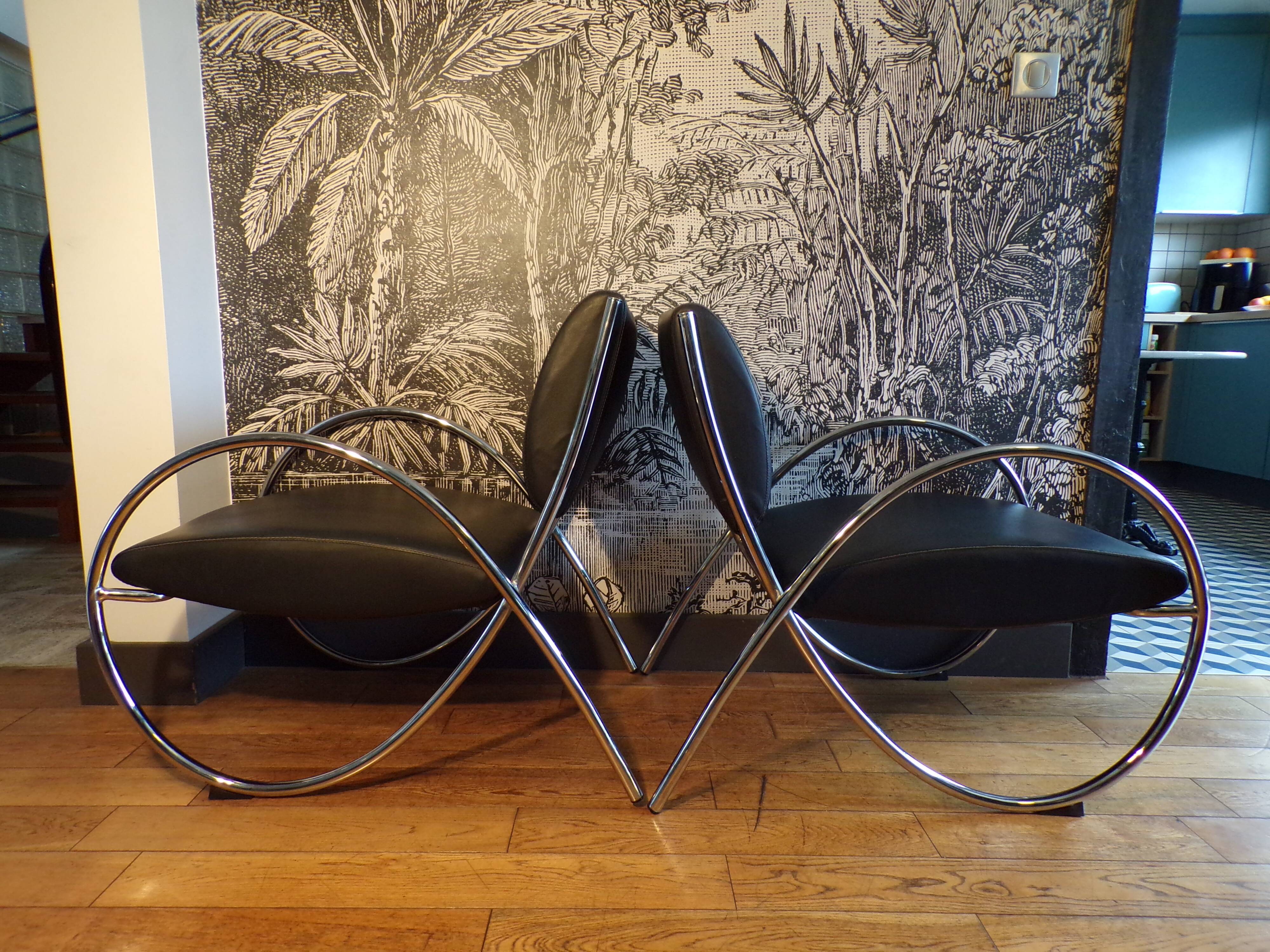 Pair of chrome and faux leather armchairs