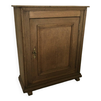 Small piece of furniture with a light oak door.