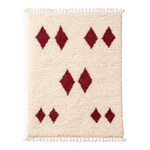Minimalist cream Berber rug with red diamonds.