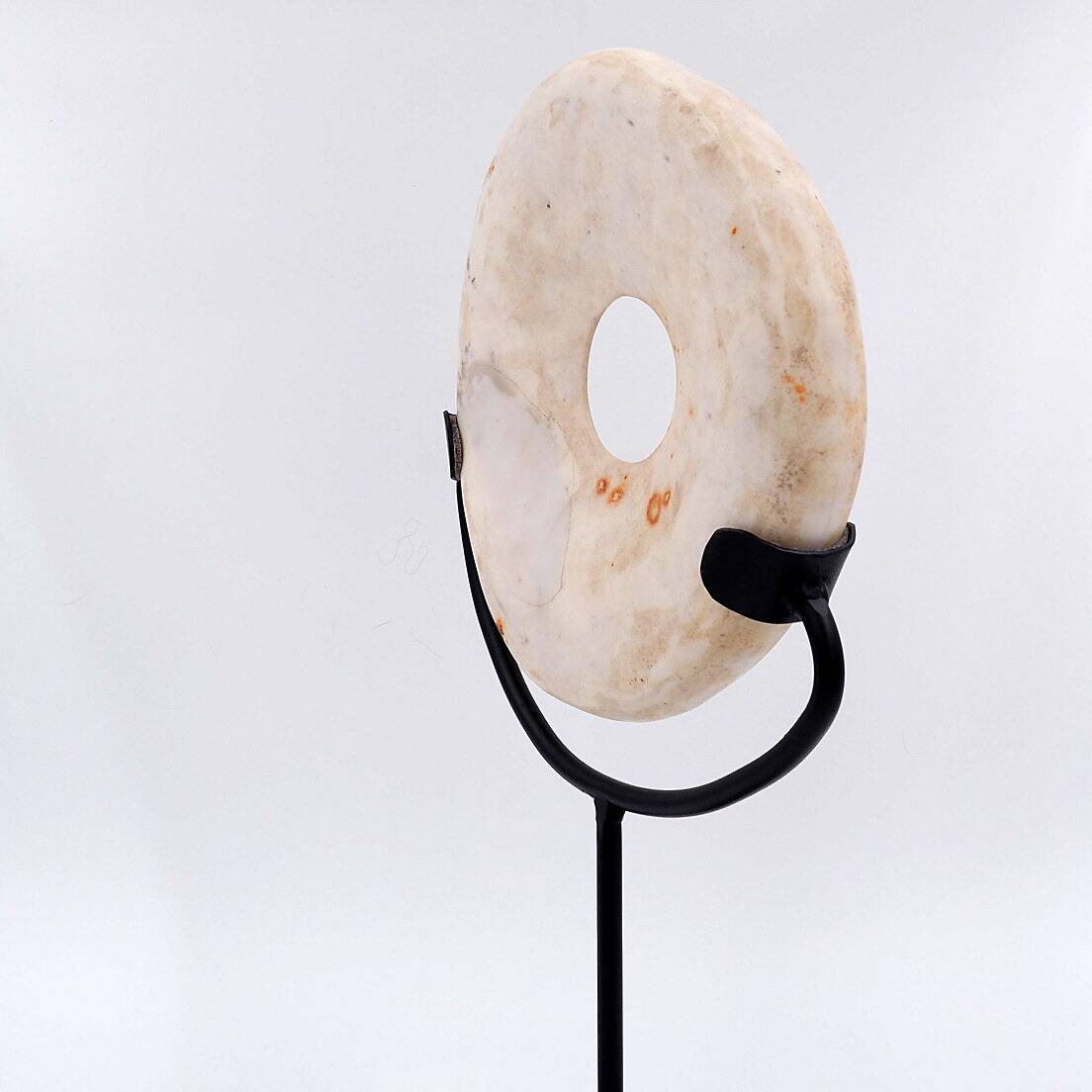 "Wamayuwa" Boiken coin in hand-carved shell mounted on a black metal stand