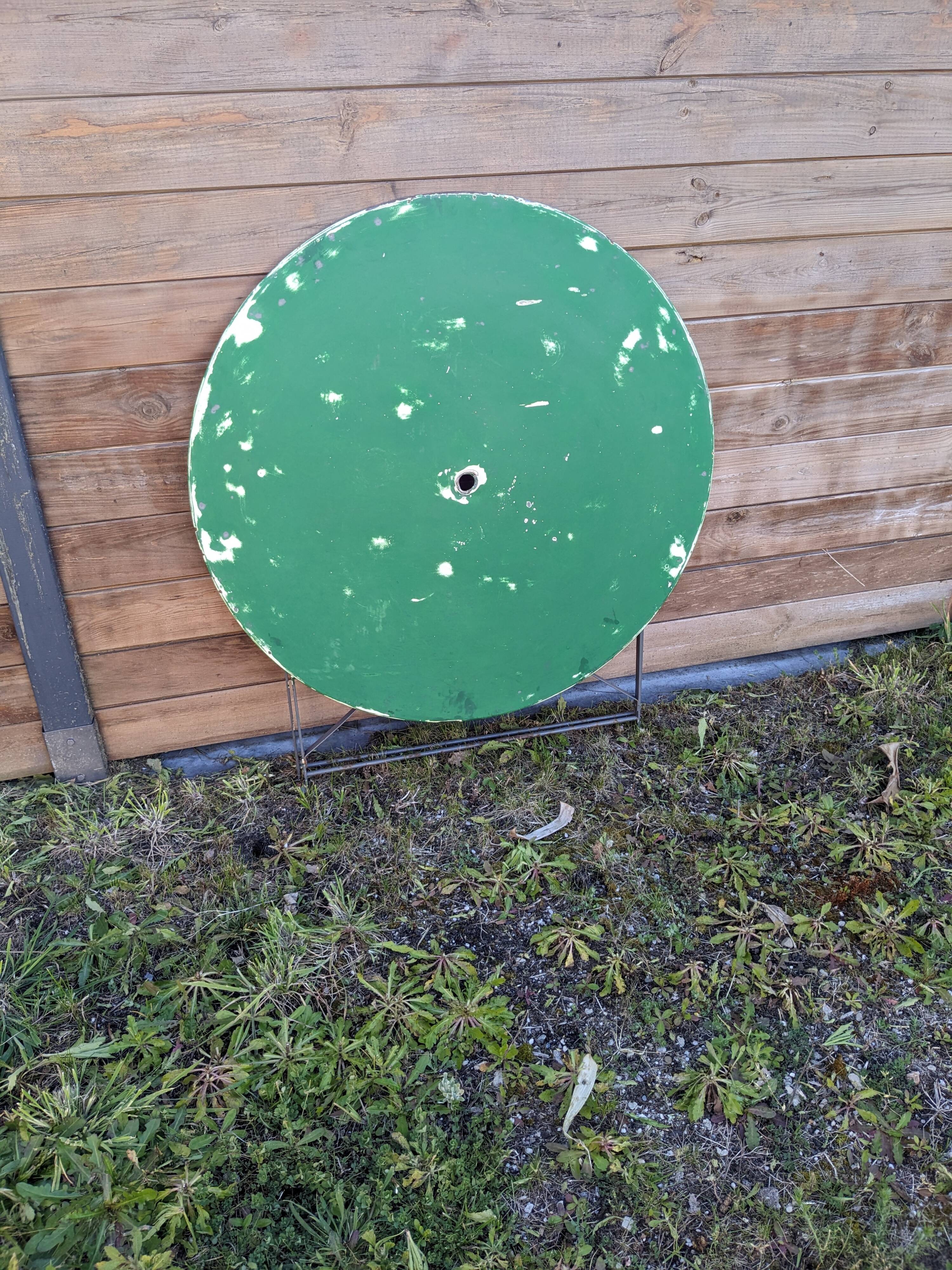 Antique round folding garden table with a green patina.