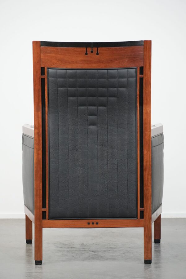 Fauteuil design Art Déco en cuir noir avec couture décorative.