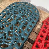 Duo of oval red and green cast iron trivets 60s 70s