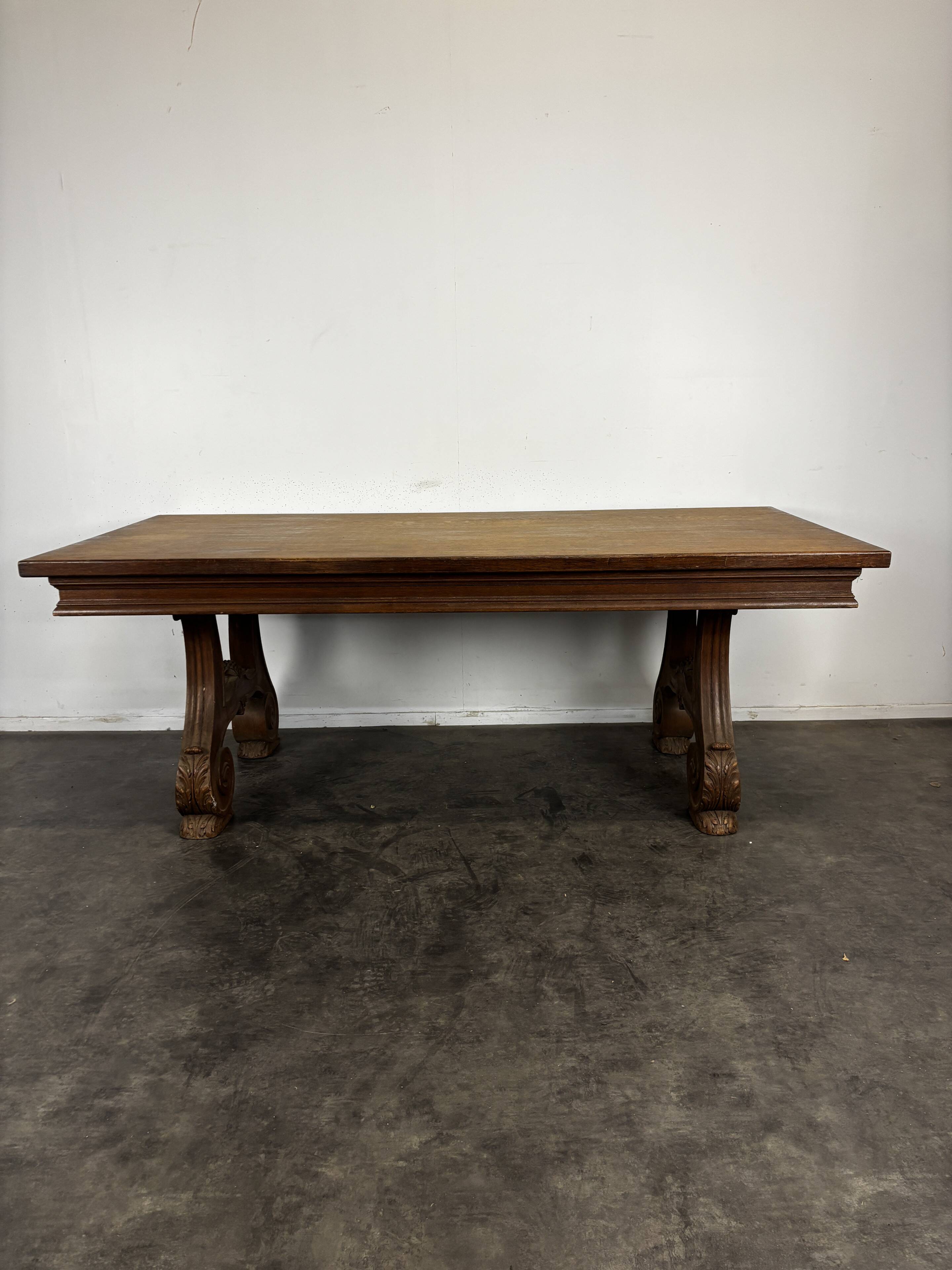 Renaissance-style oak dining table with lyre legs.