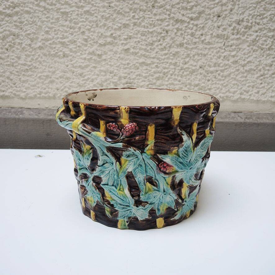 Old earthenware pot with ivy decoration.