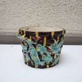 Old earthenware pot with ivy decoration.