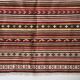 Large Indian rug with red, yellow, and white stripes and geometric fringes.