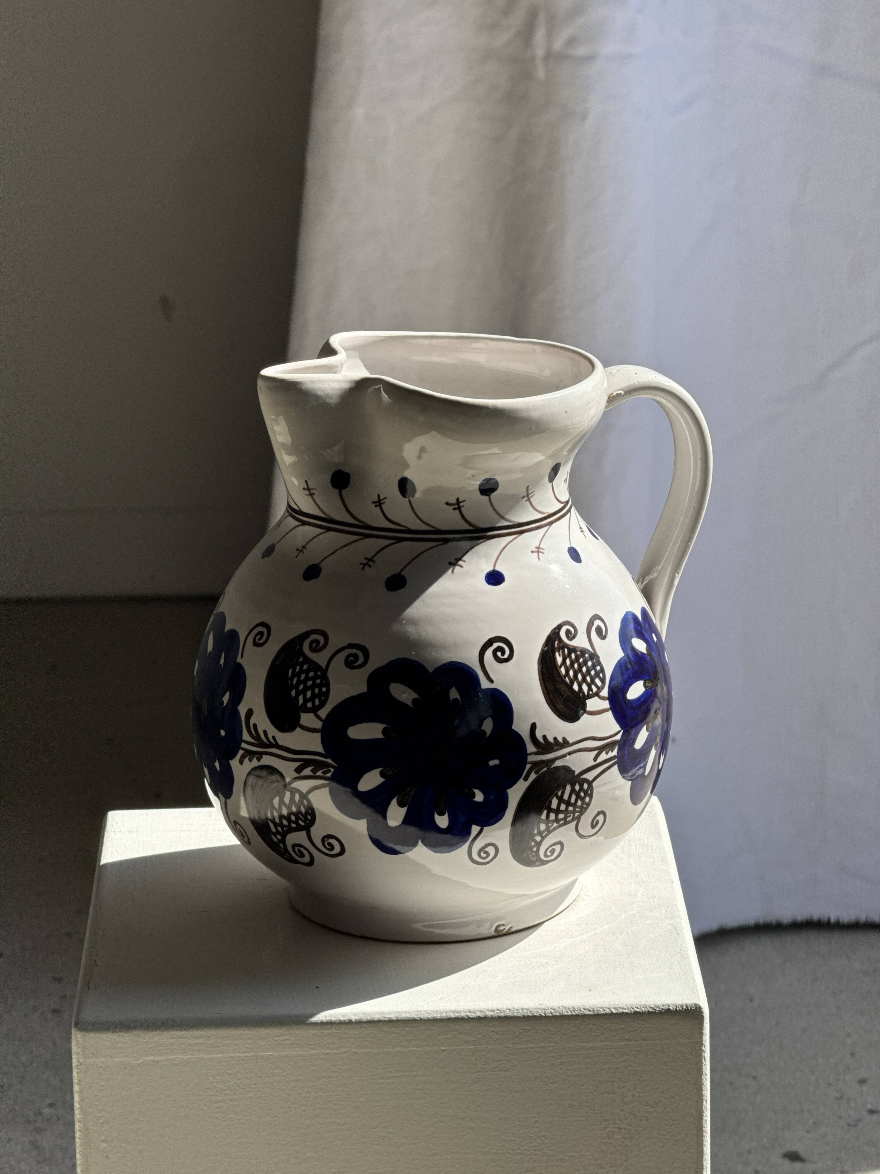 Very large vintage ceramic carafe in white glazed with blue floral decoration.