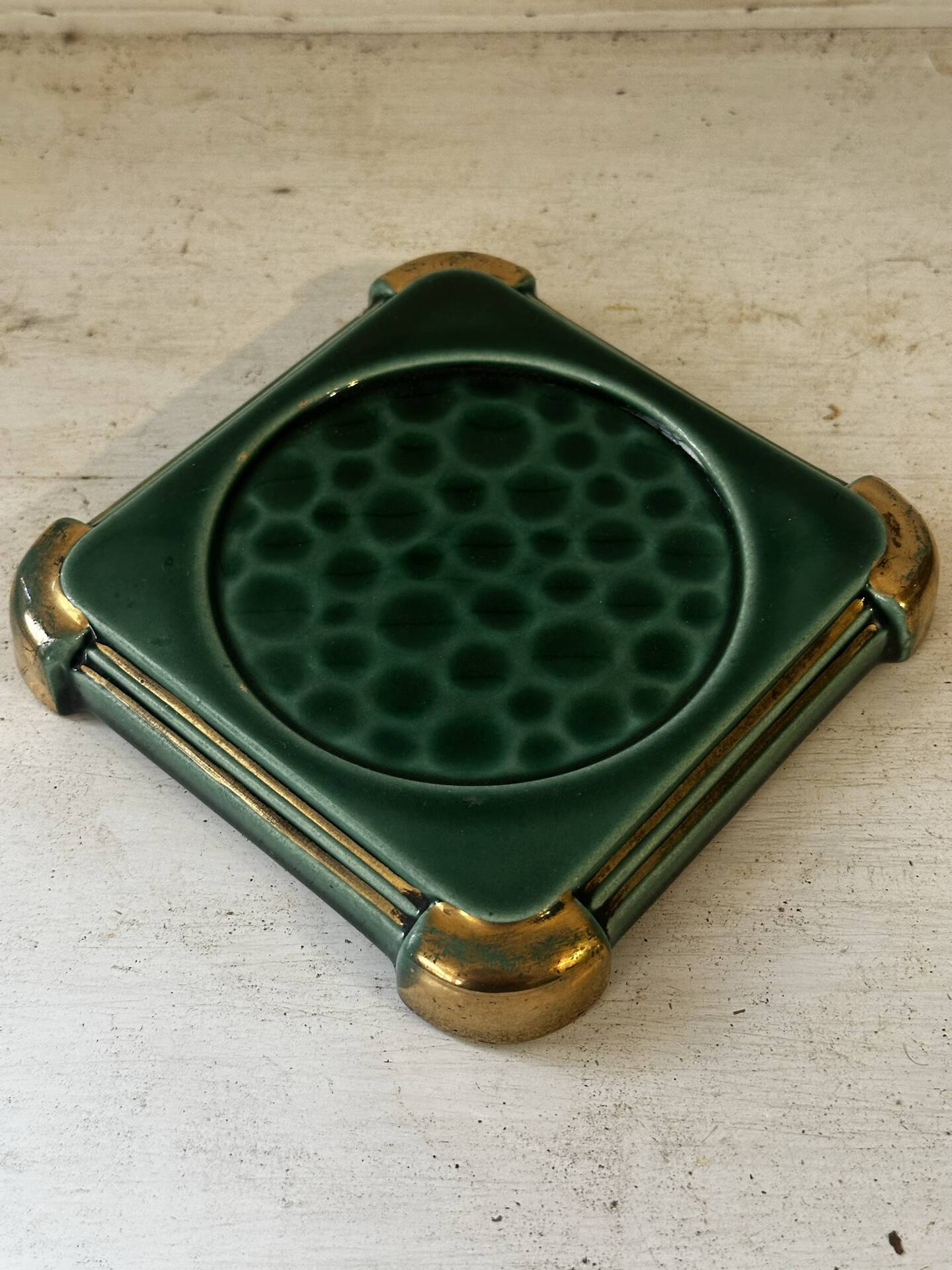Art Deco bottle coaster in speckled green glazed ceramic and